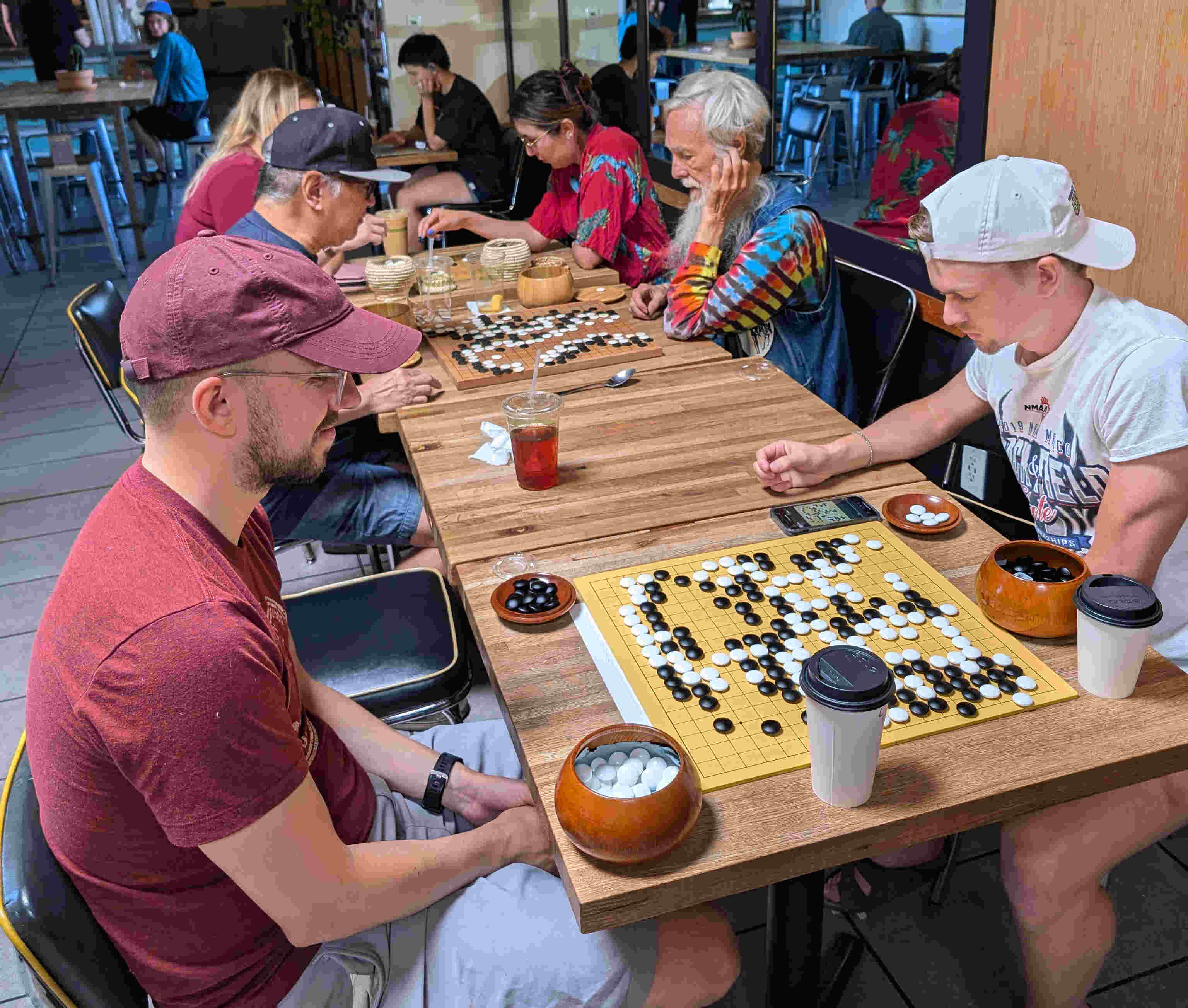 Multiple games of Go played in a cafe.